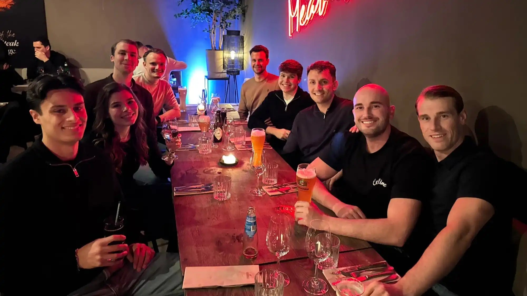 Groep mensen aan een restauranttafel.